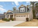 Charming single Gathering home featuring a two-car garage, covered front porch, and manicured landscaping at 488 Sandbar Pt, Clover, SC 29710