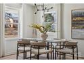 Bright dining room featuring hardwood floors, modern chandelier, and a glass-top dining table at 4931 Baylor Dr, Charlotte, NC 28210