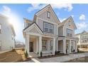 Beautiful two-story townhome with covered entry, gray siding, and landscaping at 5013 Cherry Gum Ct, Matthews, NC 28105