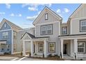 Stylish two-story townhome featuring gray siding, white trim, covered porch, and manicured landscaping at 5021 Cherry Gum Ct, Matthews, NC 28105