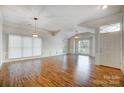 Bright, open living room with hardwood floors, crown molding, and a vaulted ceiling at 6038 Burnt Mill Run, Matthews, NC 28104