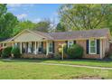 Lovely one-story brick house with black shutters and a cozy covered front porch with rocking chairs at 6349 Lebanon Rd, Mint Hill, NC 28227