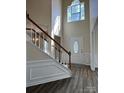 Bright foyer featuring hardwood floors, staircase, and an oval glass front door at 6827 Neuhoff Ln, Charlotte, NC 28269