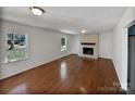 Open living room featuring hardwood floors, a brick fireplace, and natural light at 700 Hickory Ct, Gastonia, NC 28056