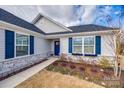 Close-up of the home entrance with a blue front door, blue shutters, and vibrant flower boxes at 715 Bonica Ct, Lancaster, SC 29720