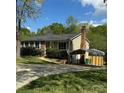 Home exterior with a carport, brick chimney, and lush green surroundings at 7939 Holly Hill Rd, Charlotte, NC 28227
