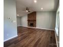 Spacious living room featuring hardwood floors, a brick fireplace, and a ceiling fan at 7939 Holly Hill Rd, Charlotte, NC 28227