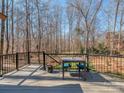 Outdoor deck with a table and chairs, perfect for enjoying the surrounding nature at 8111 Sealey Ct, Charlotte, NC 28277
