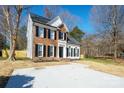 Traditional two-story home featuring brick and vinyl siding, black shutters, and a concrete driveway at 8733 Canter Post Dr, Charlotte, NC 28216