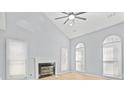 Bright living room with a fireplace, vaulted ceiling, hardwood floors, and large windows at 8733 Canter Post Dr, Charlotte, NC 28216