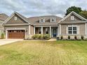 Charming single-story home featuring stone accents, dormer windows, a covered porch, and a two-car garage at 10521 Ardley Manor Dr, Mint Hill, NC 28227