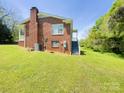 View of the backyard showing a brick home with an external staircase and grassy lawn at 108 W Jefferson St, York, SC 29745