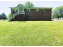 A brick two-story home features an expansive backyard with a set of stairs and white railing at 108 W Jefferson St, York, SC 29745