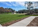 Exterior view showing well-manicured lawns and a paved walkway on a sunny day at 1202 Louise Ln, Albemarle, NC 28001