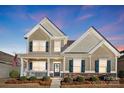 Charming two-story home featuring a welcoming front porch, landscaped yard, and neutral-toned siding at 136 Kingston Dr, Locust, NC 28097