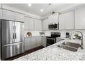Modern kitchen featuring stainless steel appliances, granite countertops, and bright, neutral gray cabinets at 136 Kingston Dr, Locust, NC 28097