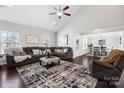 Spacious living room featuring a vaulted ceiling, stylish decor, a plush sofa, and dark wood flooring at 136 Kingston Dr, Locust, NC 28097