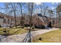 Sprawling home showing a long driveway, attached garage, and large lot with mature trees, offering privacy at 170 Anniston Way, Davidson, NC 28036