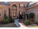 Inviting entrance with landscaped walkway, fountain, and a striking stone and brick facade, for a warm welcome at 170 Anniston Way, Davidson, NC 28036