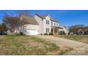 Attractive home features a 2-car garage, a vibrant red door, and a long driveway with curb appeal at 2010 Hollyhedge Ln, Indian Trail, NC 28079