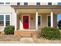 Inviting front porch showcases a bold red door, classic white columns, and manicured landscaping at 2010 Hollyhedge Ln, Indian Trail, NC 28079