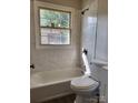 Updated bathroom featuring a tub with tile surround and a modern toilet at 2207 Madrid St, Charlotte, NC 28216