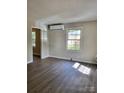 Bright living room features modern flooring, updated paint, and a newly installed air conditioning unit at 2207 Madrid St, Charlotte, NC 28216