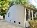 Side view of a well-maintained white brick house with a paved driveway and black window shutters at 2314 Knickerbocker Dr, Charlotte, NC 28212