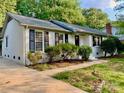 Beautiful white brick home with black shutters, lush landscaping, and a welcoming entrance at 2314 Knickerbocker Dr, Charlotte, NC 28212