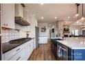 A modern kitchen with white cabinets, stainless steel appliances, and a stylish backsplash at 241 Spring Run Dr, Mooresville, NC 28117