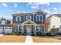 Charming two-story home featuring covered porch with stone accents and landscaped front yard at 2419 Paddlers Cove Dr, Clover, SC 29710