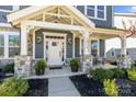 Inviting front porch with stone columns and seating area offers a welcoming entrance to the home at 2419 Paddlers Cove Dr, Clover, SC 29710