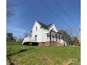 Bright white two-story house with covered porch and small side deck set on a grassy lot at 320 City Ave, Lancaster, SC 29720