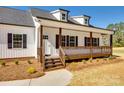 Inviting front porch with wood railing and posts on a charming white home at 453 Cedar Grove Rd, Clover, SC 29710