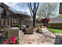 Backyard patio area with outdoor seating, brick pavers and mature trees providing shade at 5306 Wingedfoot Rd, Charlotte, NC 28226