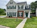 Two-story home with gray siding, brick accents, and complementary green shutters and front door at 5905 Waverly Lynn Ln, Charlotte, NC 28269