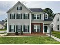 Two-story home with gray siding, brick accents, and complementary green shutters and front door at 5905 Waverly Lynn Ln, Charlotte, NC 28269