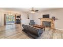 Inviting living room features a stone fireplace, ceiling fan, and wood-look flooring at 6817 Fieldlark Ln, Charlotte, NC 28227