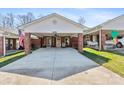 Exterior shot of a brick home, highlighting the carport, landscaped lawn, and classic architectural details at 7004 Owens Ct # B, Lowell, NC 28098