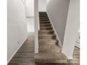 Stairway featuring neutral carpet and clean lines connecting the living spaces of this home at 7140 Stonington Ln, Charlotte, NC 28227