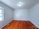 Bright bedroom with hardwood floors, a window, and neutral walls at 7515 Riding Trail Rd, Charlotte, NC 28212