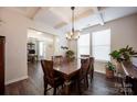 Elegant dining room showcasing coffered ceilings, oversized windows, hardwood floors and modern chandelier at 7672 Tanglewood Way, Denver, NC 28037