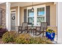 Charming front porch featuring rocking chairs, beautiful flower arrangements and craftsman style architecture at 7672 Tanglewood Way, Denver, NC 28037