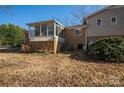 Back view of home featuring a charming sunroom, a brick foundation, and a well-maintained yard at 8080 Monbo Rd, Catawba, NC 28609