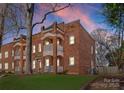 Charming brick apartment building with multiple balconies and mature trees at dusk at 843 Ideal Way # 10, Charlotte, NC 28203