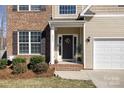 Cozy front porch with decorative wreath, charming details, and an attached two-car garage at 8822 Crape Myrtle Dr, Stanfield, NC 28163