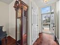Inviting foyer with hardwood floors, a grandfather clock, and a view of the front door and outside at 8830 Cinnabay Dr, Charlotte, NC 28216