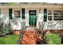 Welcoming front entrance with a vibrant green door, brick steps and matching shutters at 908 Dogwood Dr, Gastonia, NC 28054