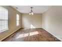 Neutral living room with wood floors, chandelier, and natural light, offering versatile design at 9900 Meadowmead Ct, Charlotte, NC 28273