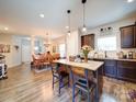 Inviting kitchen featuring an island, granite countertops, dark cabinets, and an adjacent dining area perfect for entertaining at 1232 Scotch Meadows Loop, Monroe, NC 28110